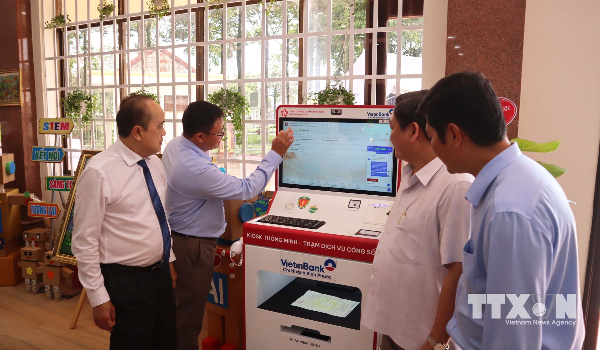 Các đại biểu tìm hiểu hoạt động của Kiosk thông minh - Trạm Dịch vụ công số tại phường Bình Phước. (Ảnh: Đậu Tất Thành/TTXVN)